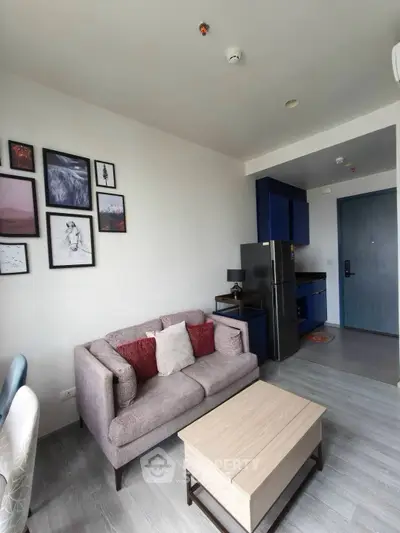 Modern living room with stylish decor and compact kitchen in open layout apartment.