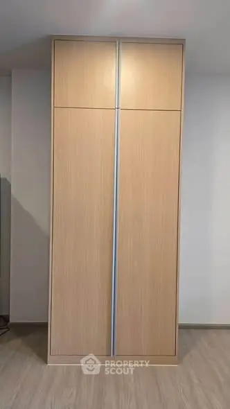 Modern wooden wardrobe with sleek design in a minimalist interior setting.