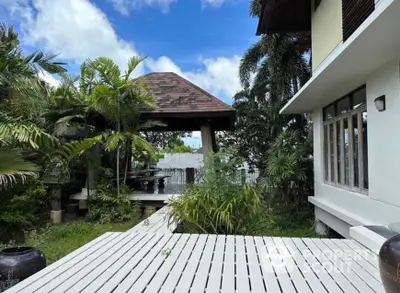 Tropical garden with gazebo and modern house exterior, perfect for relaxation and outdoor gatherings.