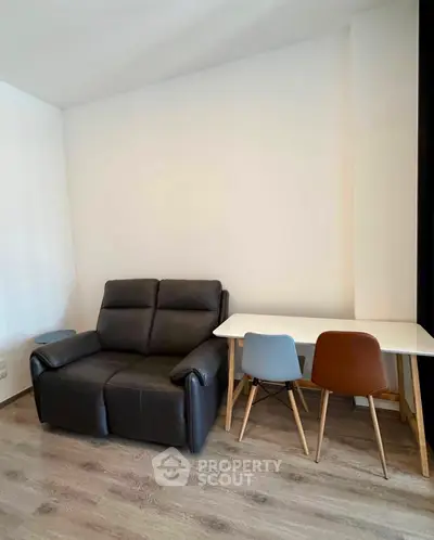 Cozy living room with modern sofa and dining table, perfect for small apartments.