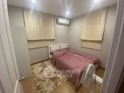 Cozy bedroom with pink bedding and air conditioning in modern apartment.