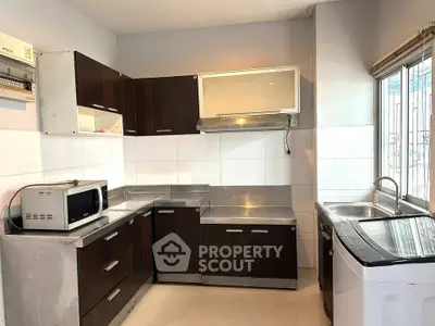 Modern kitchen with stainless steel appliances and dark wood cabinets