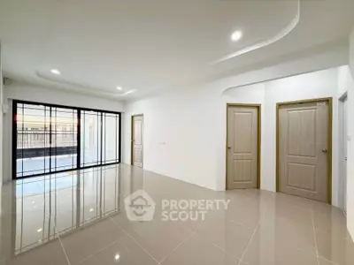Spacious modern living room with glossy tiled floors and large windows for natural light.