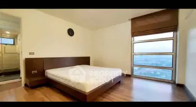 Spacious bedroom with large window offering stunning city views and modern decor.