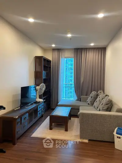 Modern living room with cozy sofa, TV, and city view window.