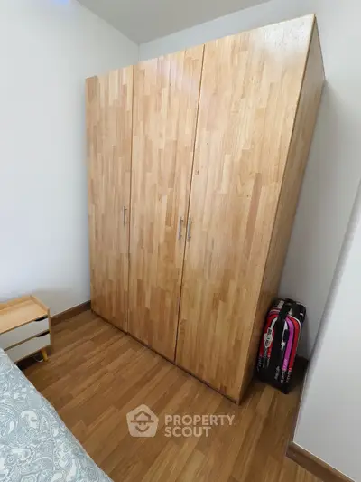 Spacious bedroom with wooden wardrobe and modern decor