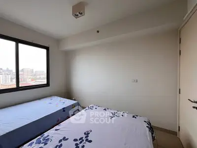 Cozy bedroom with twin beds and city view from window