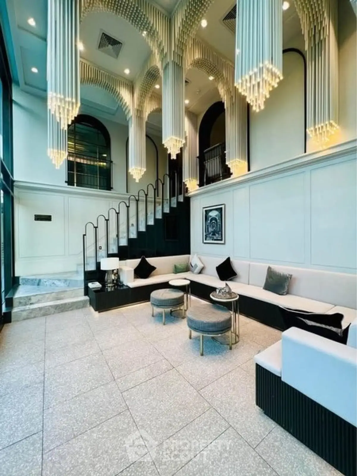 Luxurious modern living room with high ceilings and elegant chandeliers in a stylish apartment.