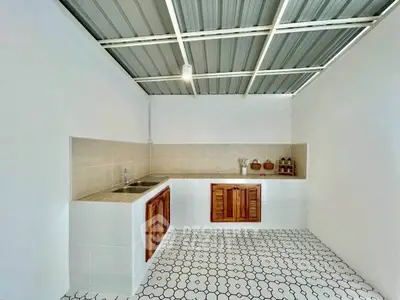 Spacious kitchen with modern design and tiled flooring, featuring a sleek metal ceiling.