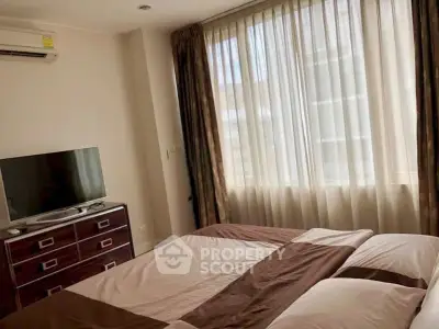 Cozy bedroom with natural light and modern furnishings in a stylish apartment.