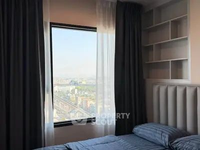 Cozy bedroom with a stunning city view from a large window, featuring elegant curtains and built-in shelves.