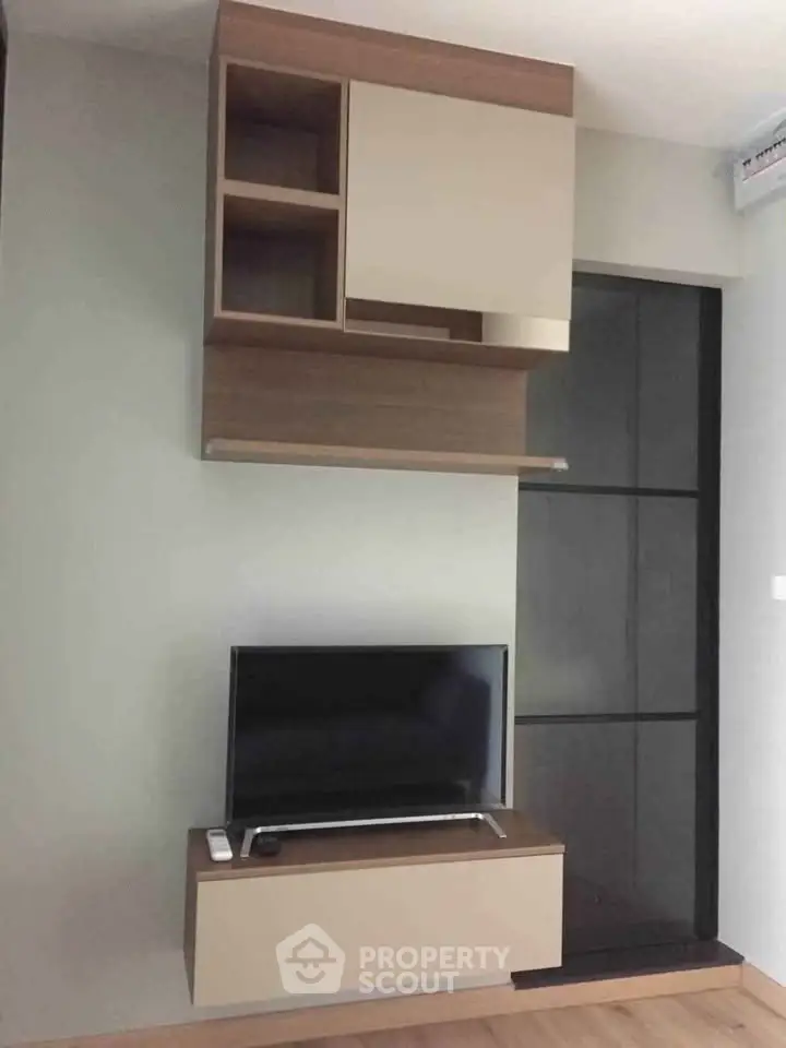 Modern living room with sleek TV unit and stylish wall cabinets in contemporary apartment.