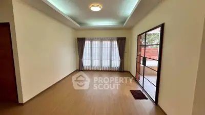 Spacious living room with large windows and wooden flooring