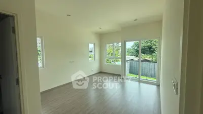 Spacious room with large windows and balcony overlooking lush greenery, perfect for natural light lovers.