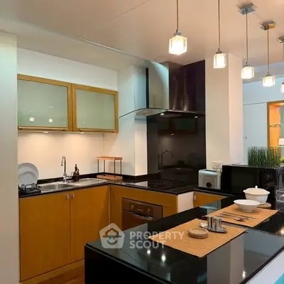 Modern kitchen with sleek black countertops and stylish lighting