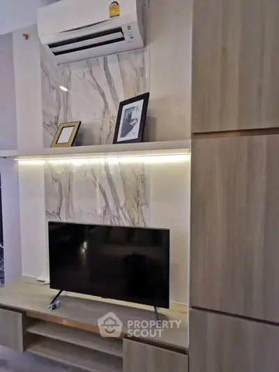 Modern living room with sleek TV setup and stylish air conditioning unit.