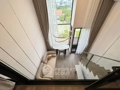 Luxurious loft-style living room with high ceilings and stunning city view, featuring elegant modern furniture and large windows.