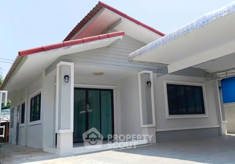 Charming single-story house with modern exterior and spacious driveway.