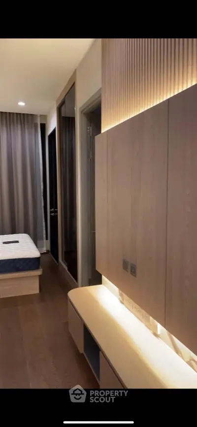 Modern bedroom with sleek wooden cabinetry and ambient lighting