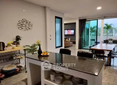 Spacious open-plan kitchen and living area with modern decor and large windows.