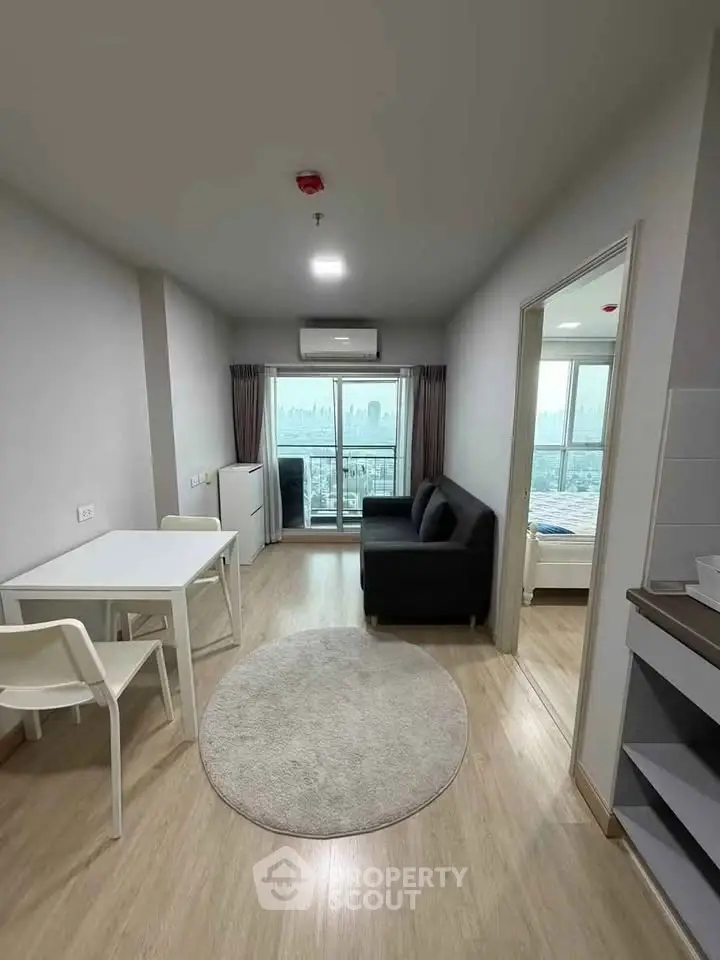 Modern living room with city view, featuring sleek furniture and natural light.