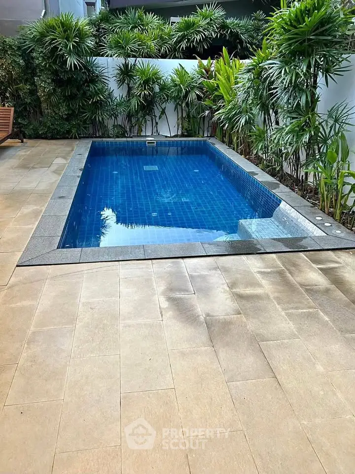 Luxurious private pool surrounded by lush greenery in a serene outdoor setting.
