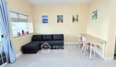 Bright living room with modern sofa and dining area, perfect for relaxation and entertaining.