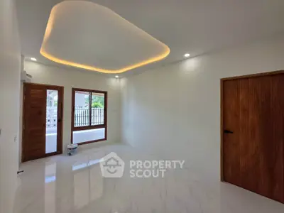 Spacious modern living room with elegant ceiling lighting and large windows.