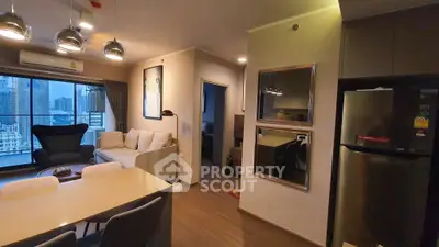 Modern living room with city view, stylish furniture, and open kitchen layout in a high-rise apartment.