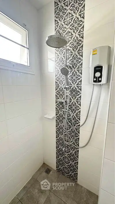 Modern bathroom shower with stylish tile design and window for natural light.