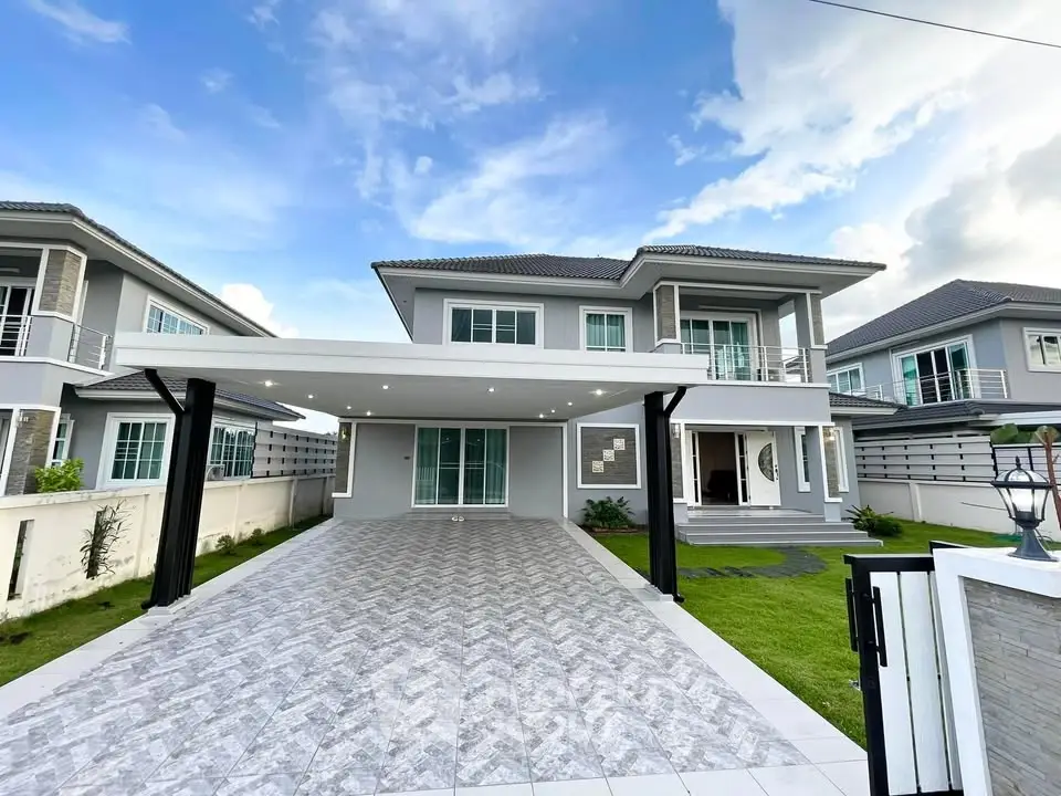 Stunning modern two-story house with spacious driveway and lush green lawn, perfect for family living.