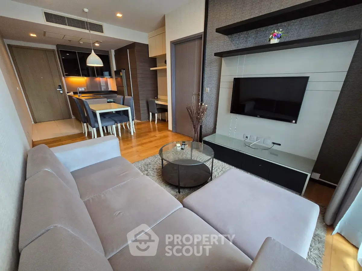 Modern living room with sleek furniture and open kitchen layout in a stylish apartment.