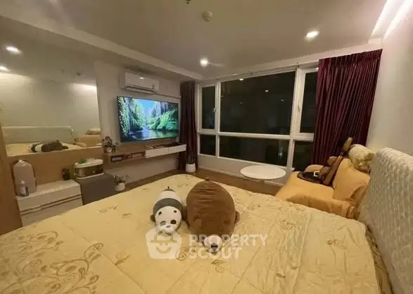 Cozy bedroom with large window and modern decor, featuring plush toys and ambient lighting.