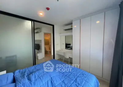 Modern bedroom with blue bedding, built-in wardrobe, and ensuite bathroom.