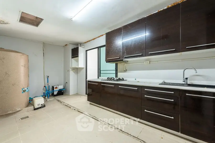 Spacious kitchen with dark cabinets and gas stove, ideal for modern cooking.
