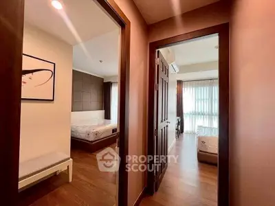 Spacious apartment interior with wooden flooring and modern decor, featuring two bedrooms with ample natural light.