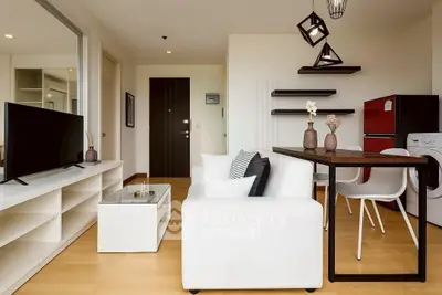 Modern living room with stylish furniture and open kitchen layout in a contemporary apartment.