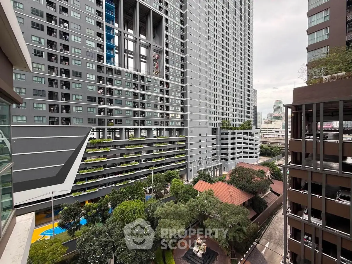 Modern high-rise building with lush greenery and urban view, perfect for city living.