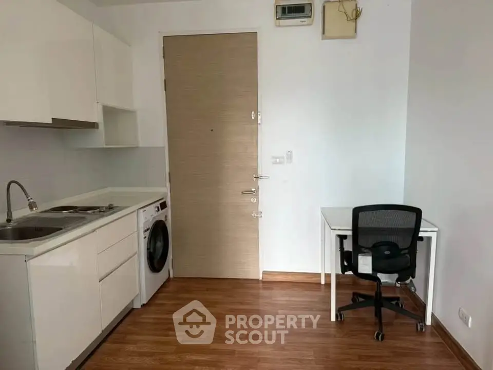 Compact studio apartment with kitchenette and workspace, ideal for urban living.