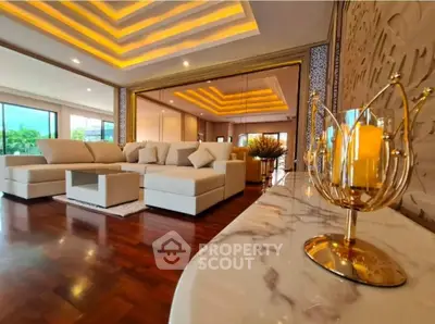 Luxurious living room with elegant lighting and plush seating, featuring a stylish marble table and decorative accents.