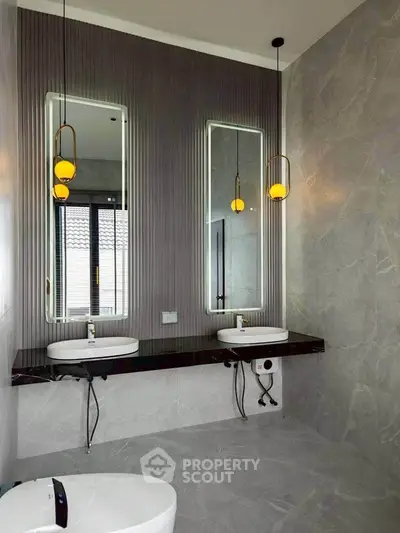 Luxurious modern bathroom with dual sinks and elegant lighting fixtures.