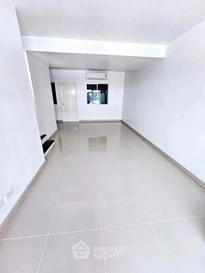 Spacious modern living room with glossy tiled floors and air conditioning.