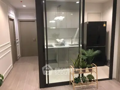 Modern kitchen with glass partition and sleek appliances in stylish apartment.