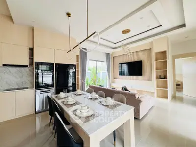 Modern open-layout kitchen and living room with elegant dining setup and large TV.
