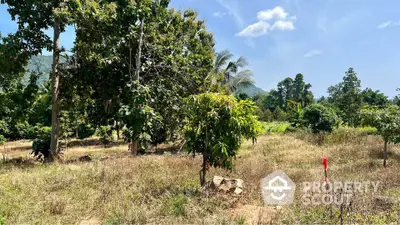 Scenic land plot with lush greenery and mountain backdrop, perfect for development or investment.