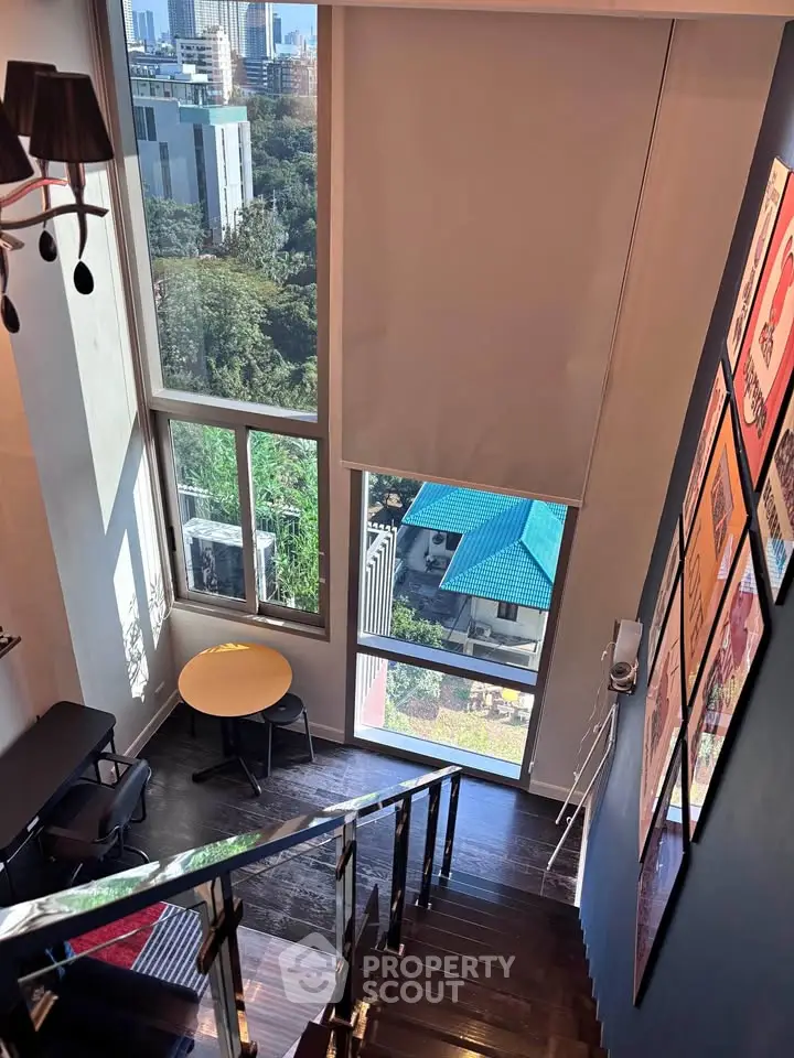 Stunning loft with floor-to-ceiling windows offering a breathtaking city view, perfect for modern urban living.