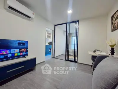 Modern living room with sleek design and sliding glass doors leading to a cozy bedroom.