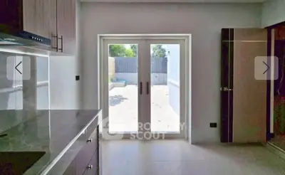 Modern kitchen with sleek design and garden view through glass doors