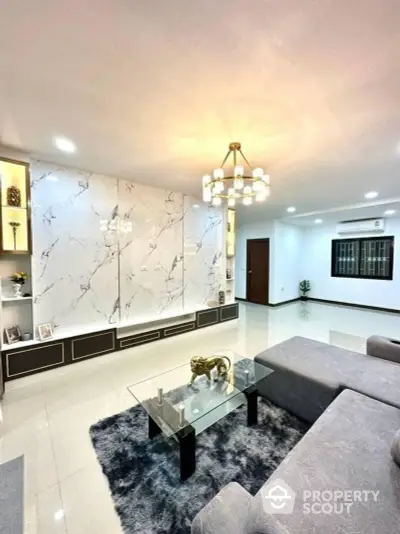 Elegant living room with marble feature wall, plush furnishings, and chic lighting, perfect for upscale urban living.