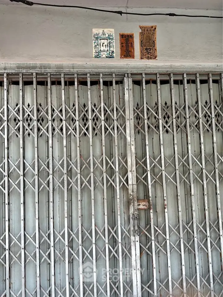 Secure metal gate entrance with traditional decor in urban setting